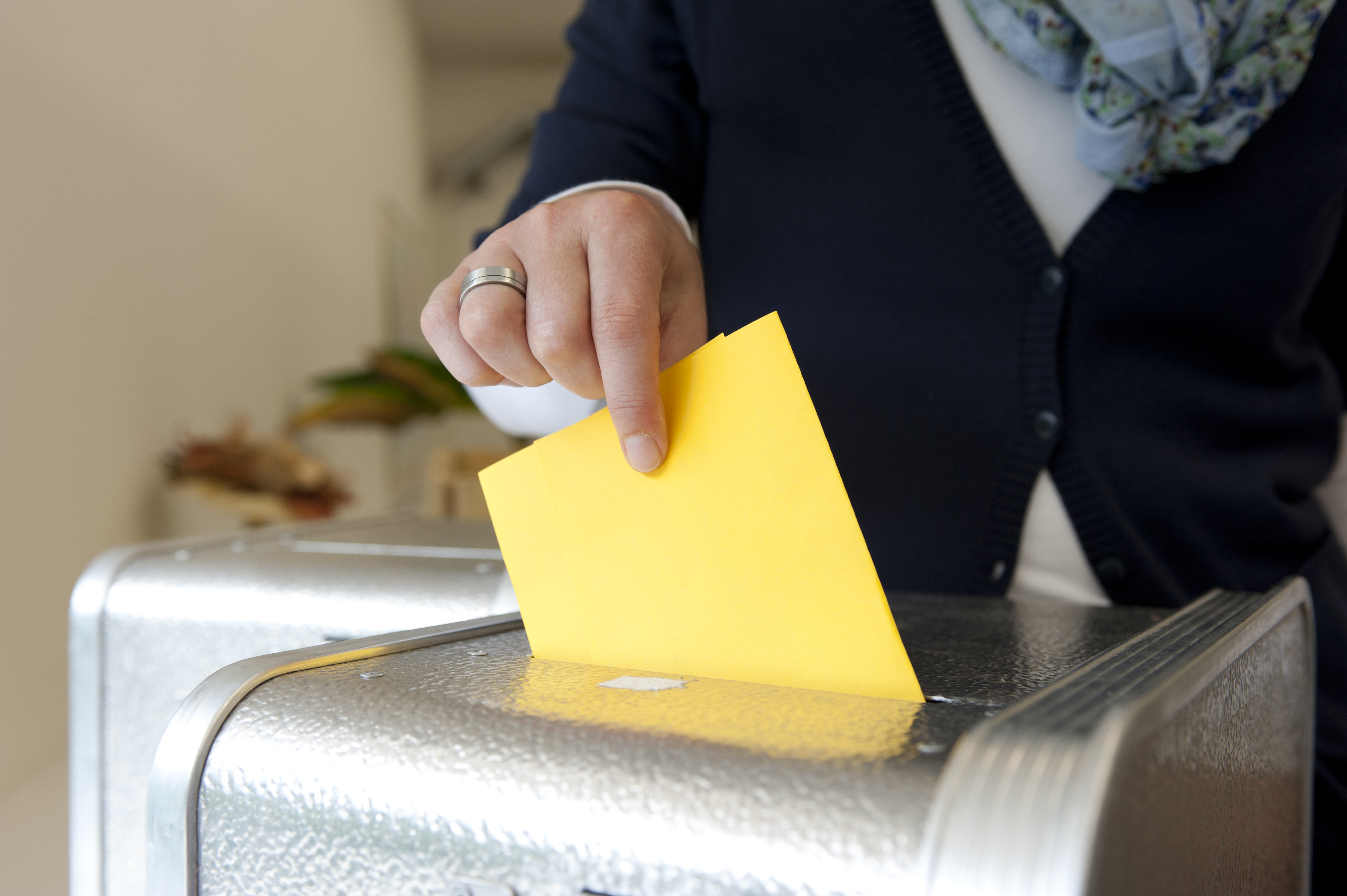 Stimmzettel wird in die Wahlurne eingeworfen