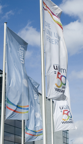 Fahnen "UniUlm feiert" Fahnen mit der Aufschrift "Uni Ulm feiert" flattern im Wind
