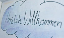 Foto von Flipchart mit Schriftzug "Herzlich Willkommen"