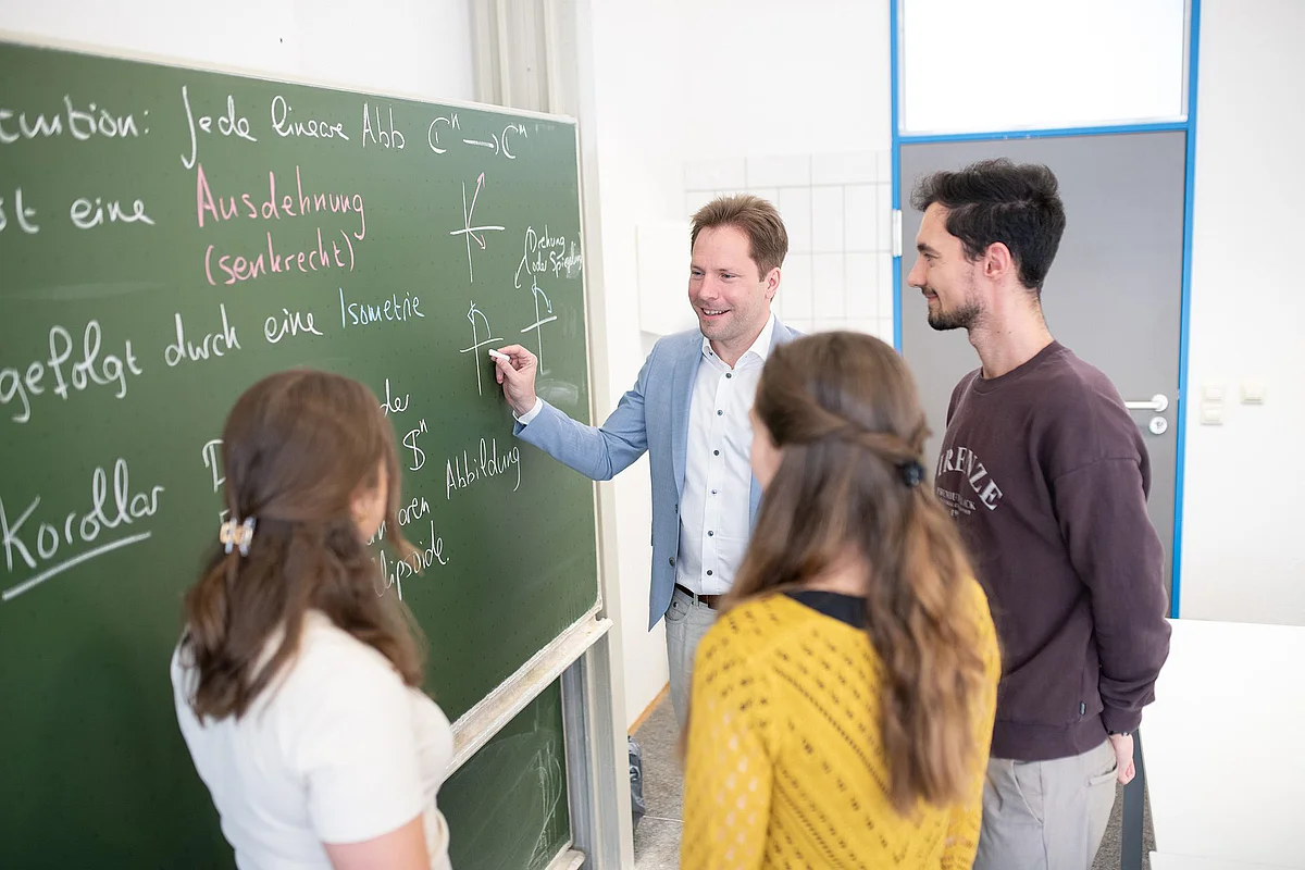 Dozent mit Studierenden der Wirtschaftsmathematik