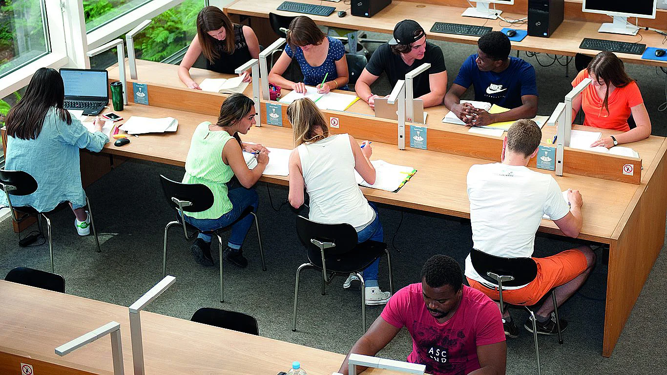 Studierende verschiedener Nationen lernen gemeinsam in der Bibliothek