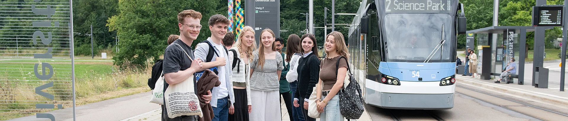 Studierende an der Straßenbahnhaltestelle Universität Süd