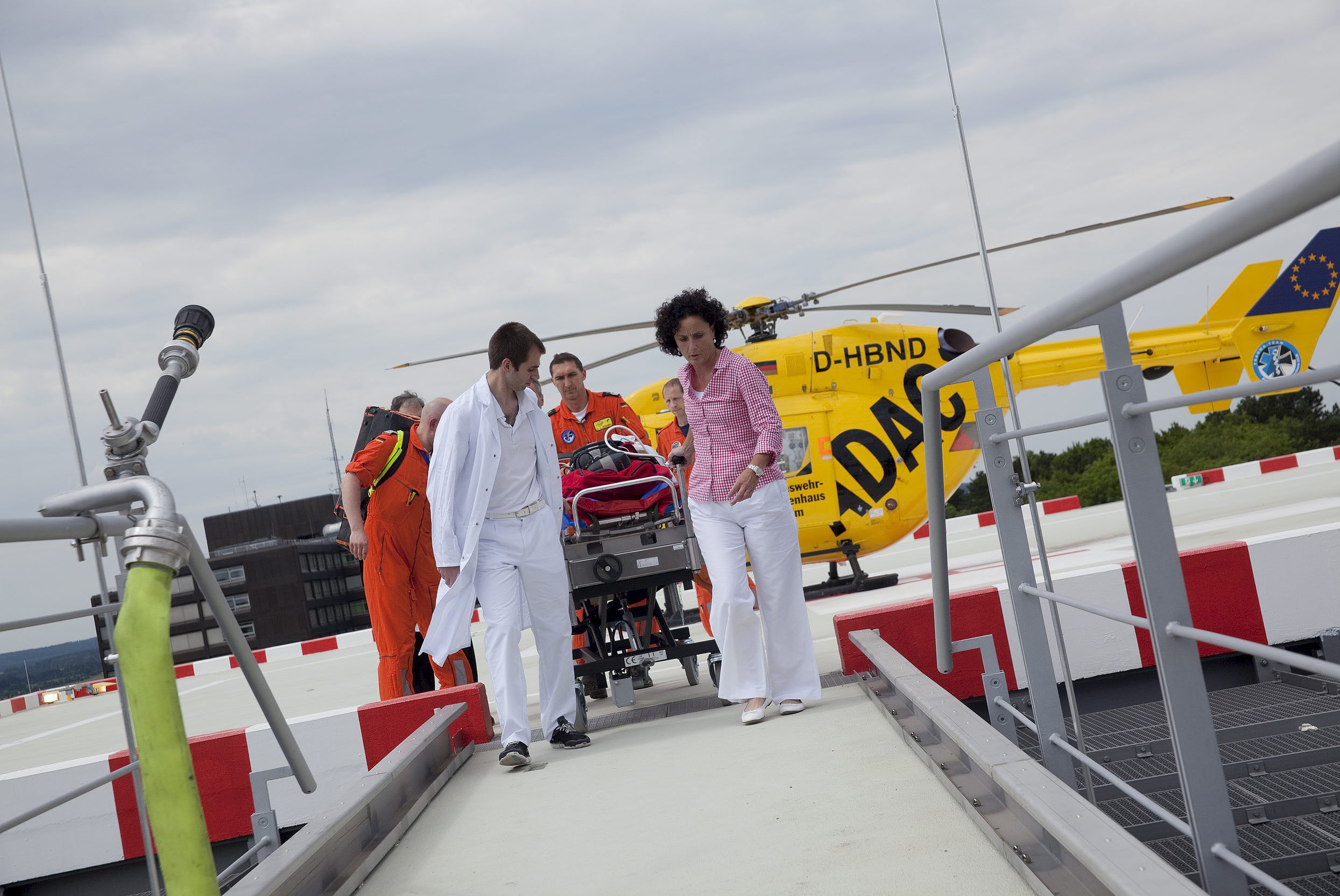 Medizinisches Personal transportiert einen verletzten Patienten auf einer Liege über den Hubschrauberlandeplatz der Universitätsklinik Ulm.