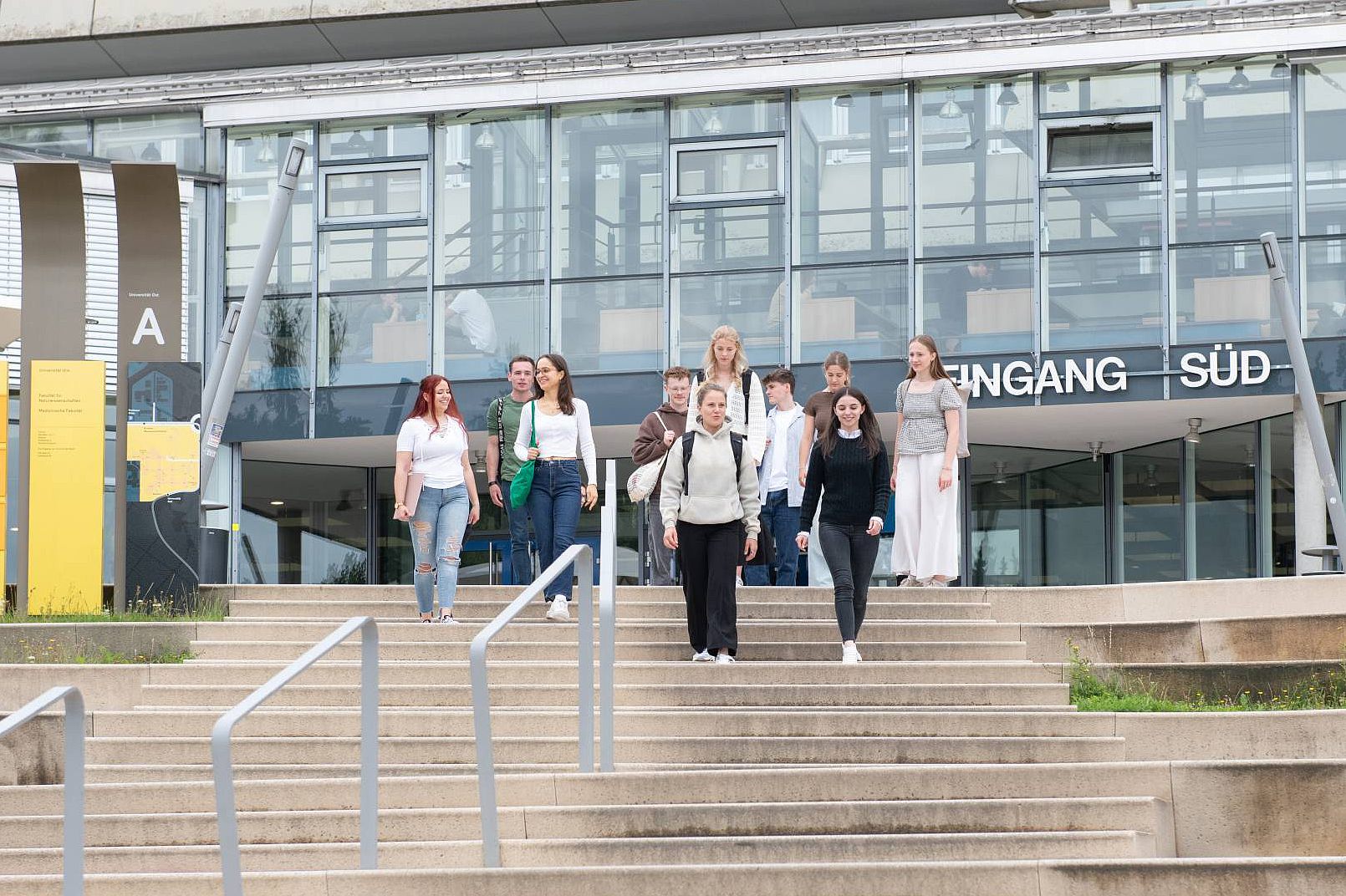 Studierende laufen den Treppenstieg am Eingang Süd der Universität hinunter.