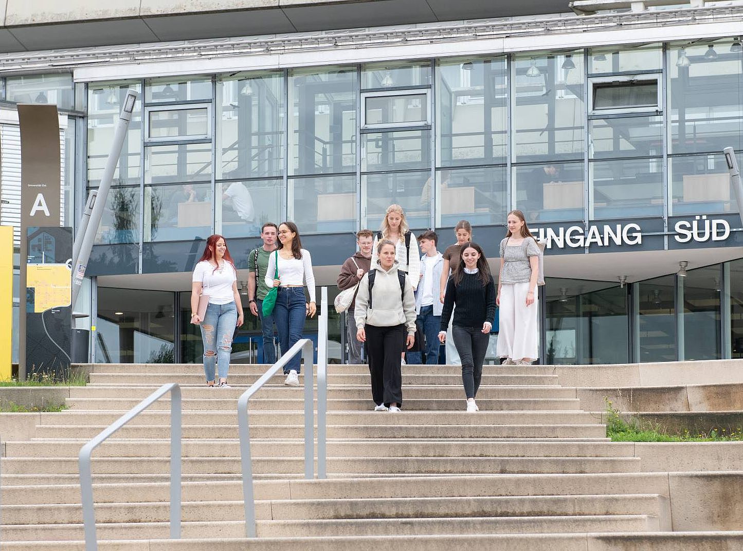 Studierende laufen den Treppenstieg am Eingang Süd der Universität hinunter.