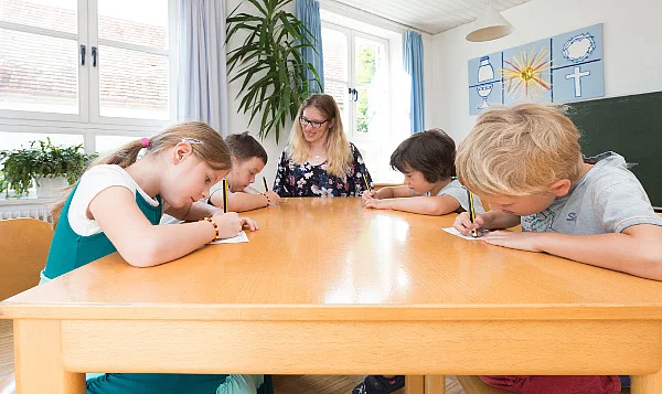 Kinder schreiben mit Bleistift auf Papier 