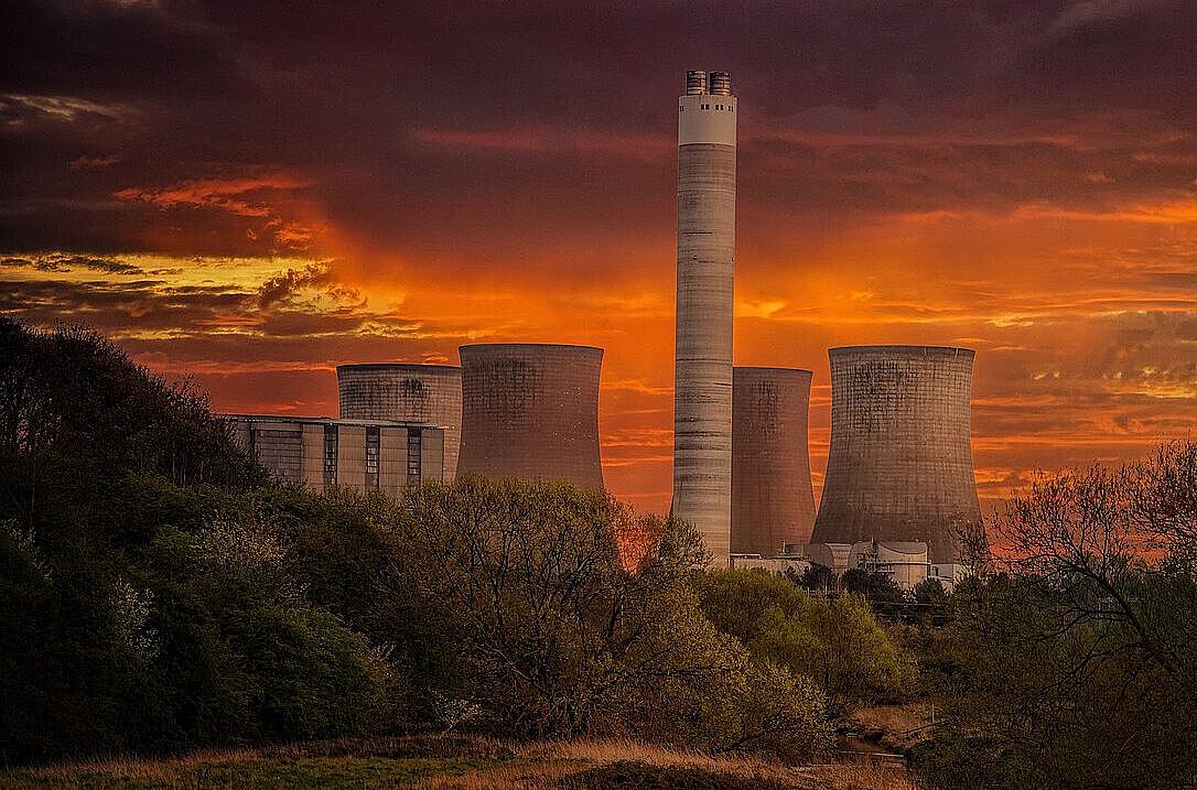 [Translate to english:] Düsteres Atomkraftwerk im Abendrot