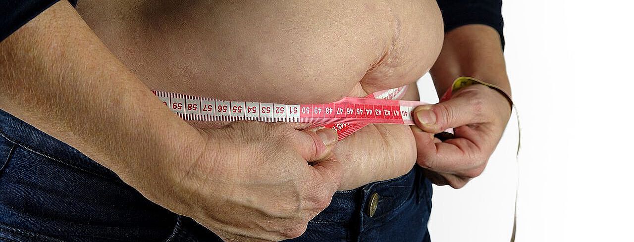 »Browning« von Fettgewebe Mann legt Maßband um seinen Bauch