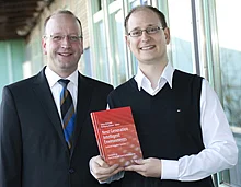 Nicht ohne Stolz präsentieren Prof. Wolfgang Minker (links) und Tobias Heinroth das Fachbuch, das die Ergebnisse des Projekts dokumentiert und jetzt in einem renommierten Wissenschaftsverlag erschienen ist