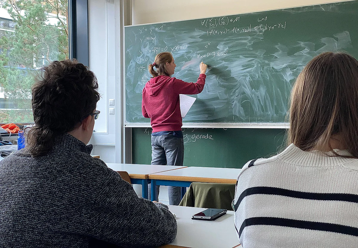 Studentischer Tutor rechnet an der Tafel 