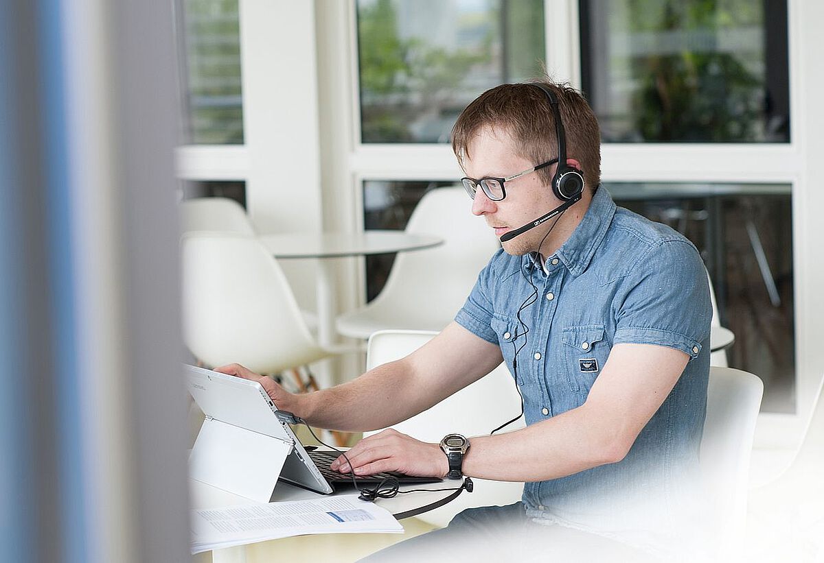 Man at laptop with headset