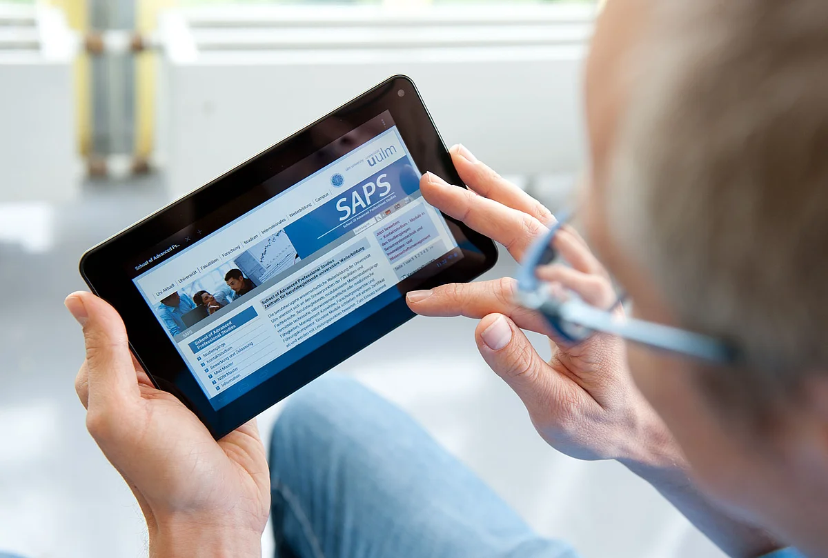 Ein Mann surft auf der SAPS-Homepage mit einem Tablet