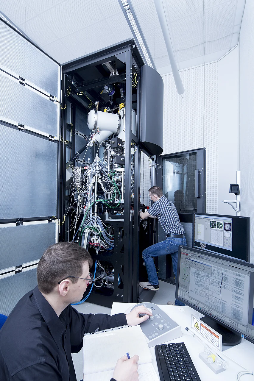 Wissenschaftler bei Einstellarbeiten am SALVE-Mikroskop. Links unten am Bildschirm der Ulmer Physiker Dr. Johannes Biskupek, im Hintergrund am Gerät Dr. Martin Linck (Firma CEOS)