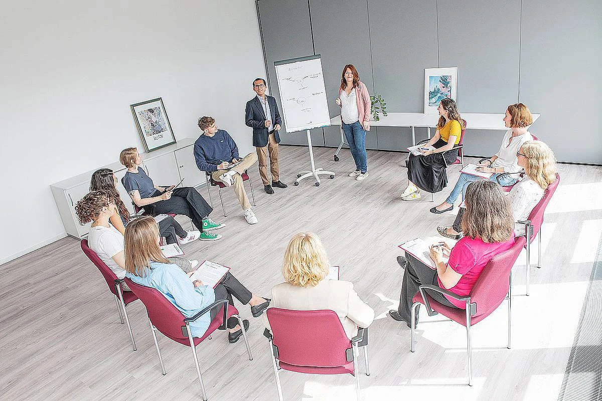 Dr. Roberto Rojas (Bildmitte hinten) in einer Besprechung mit Mitarbeiterinnen und Mitarbeitern der Psychotherapeutischen Hochschulambulanz