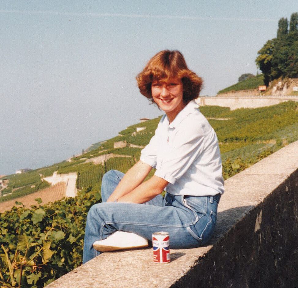 Marion Gruber als Studentin sitzend auf einer Mauer