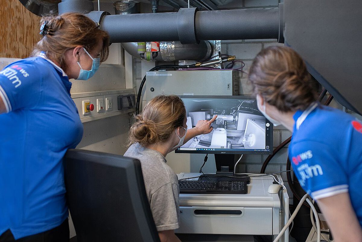Wissenschaftlerinnen vom Ulmer Institut für Energiewandlung und -speicherung verfolgen am Monitor Kamerabilder aus dem Inneren des Teststandes.