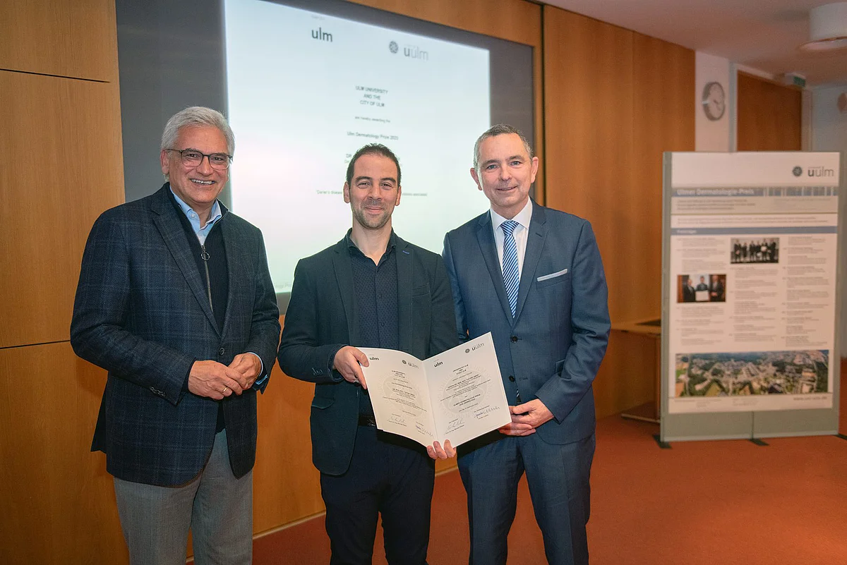 Der Ulmer Oberbürgermeister Gunter Czisch (links) und Professor Michael Kühl (rechts), Vizepräsident für Kooperationen der Uni Ulm, übergaben Dr. Yacine Amar den Ulmer Dermatologiepreis 2023