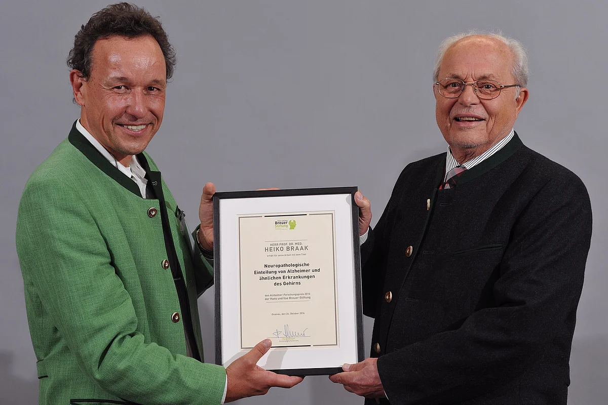 Prof. Christian Haass (li.), Kuratoriumsmitglied der Hans und Ilse Breuer-Stiftung, übergibt den Preis an Prof. Heiko Braak