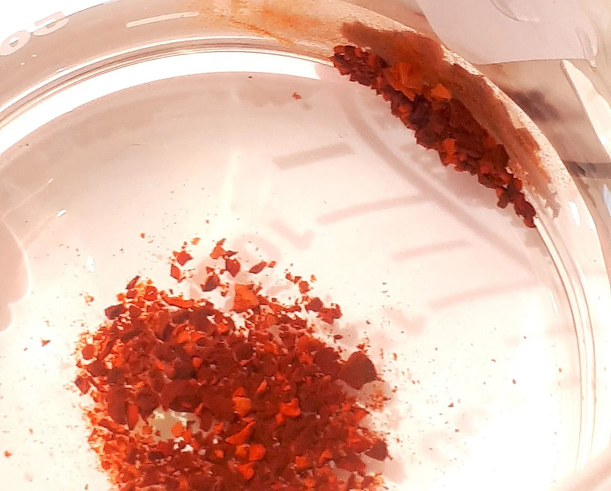 An iron oxide core equips the nanoparticles with magnetic properties. In this picture, they appear as reddish-brown particles, which can be moved to the periphery with the help of a magnet (Photo: Archismita Misra / Ulm University)
