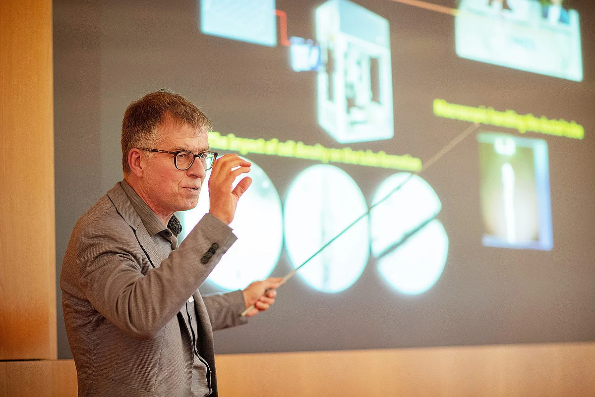 Prof Jan Tuckermann stands in front of a presentation and explains