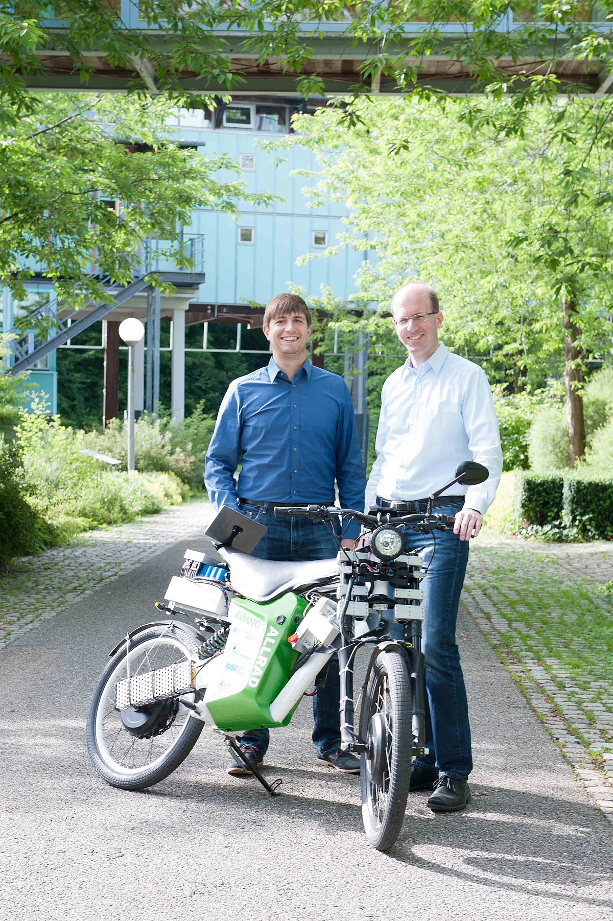 Projektkoordinator Dr. Michael Buchholz (r.) und Wissenschaftlicher Mitarbeiter Matthias Baumann mit dem Prototypen eines rein elektrisch betriebenen Allrad-Leichtkraftrads 