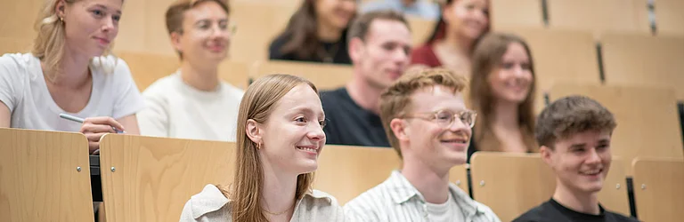 Studierende sitzen im Hörsaal und schauen nach vorne