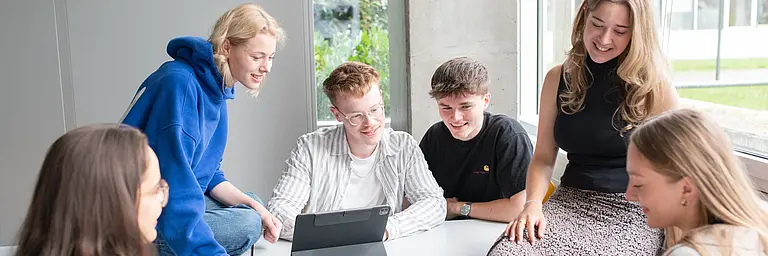 Eine Gruppe Studierender sitzt in einem Seminarraum zusammen