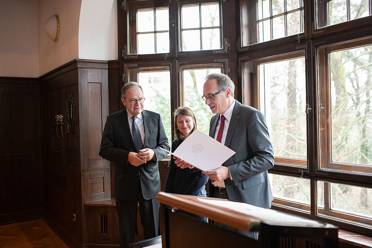 Prof. Joachim Ankerhold und UUG-Vorstand Manfred Oster übergeben die Urkunde an Dr. Sarah E. Pfeffer
