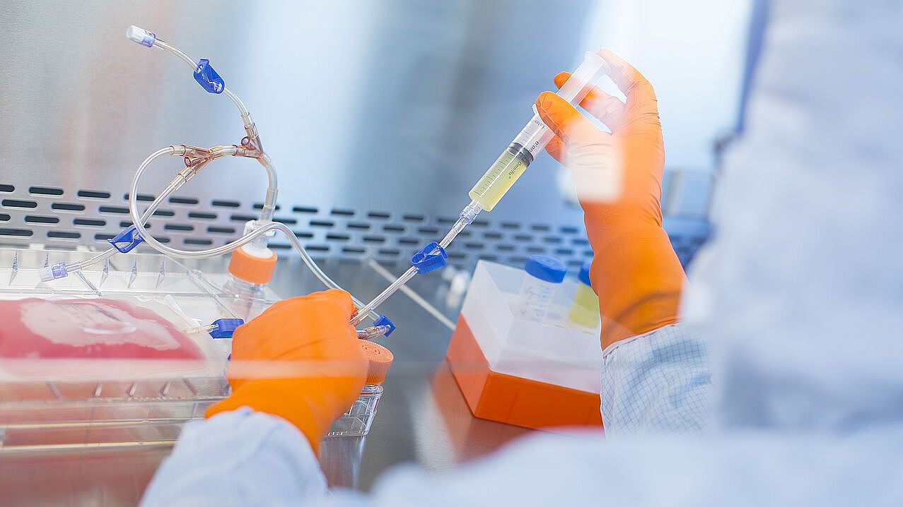Biomedizinisches Forschungslabor Ein Laborant mit Spritze in der Hand - Bild verlinkt auf die Forschungsseite