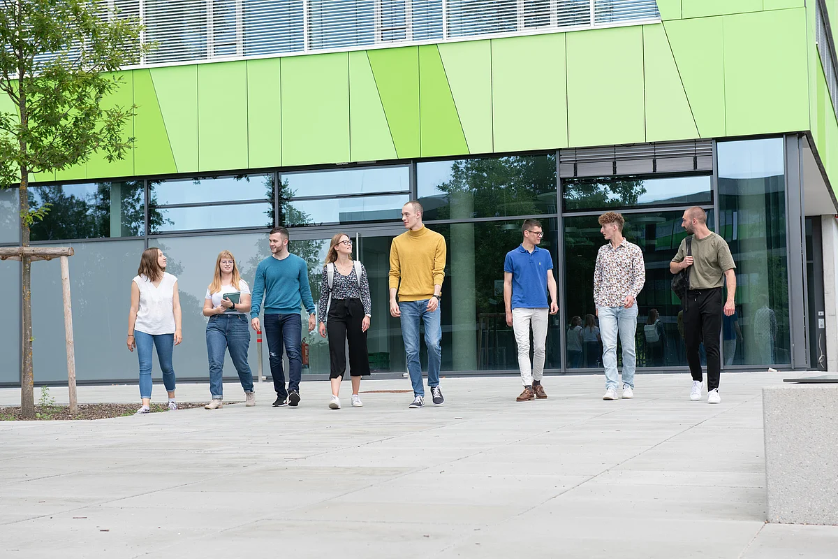 Personen laufen vor einem Gebäude