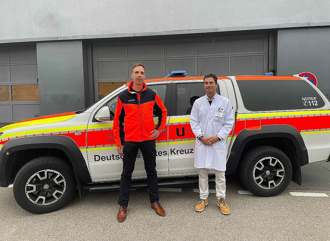 Dr. Benedikt Schick mit Prof. Carlos Schönfeldt-Lecuona vor einem Notarztwagen 