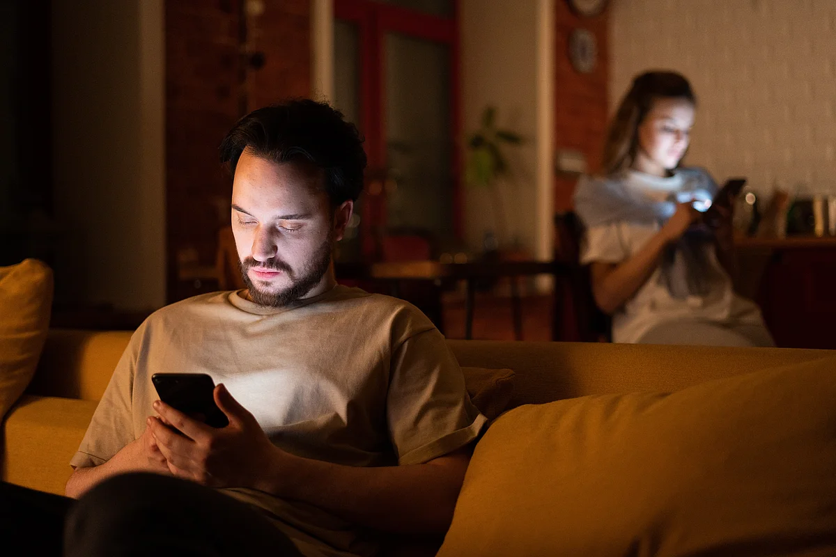Mann mit Smartphone auf dem Sofa