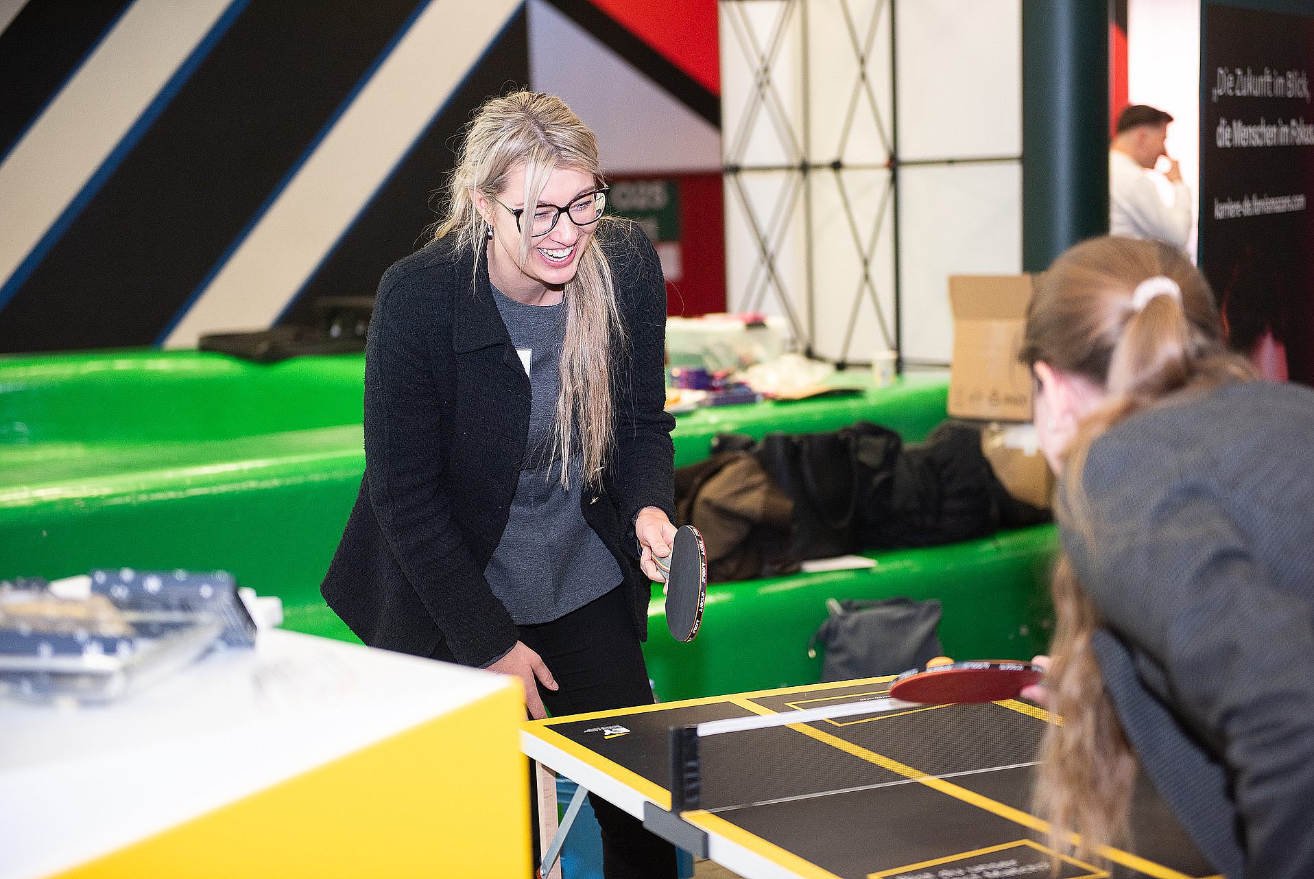 Students and company representative play table tennis