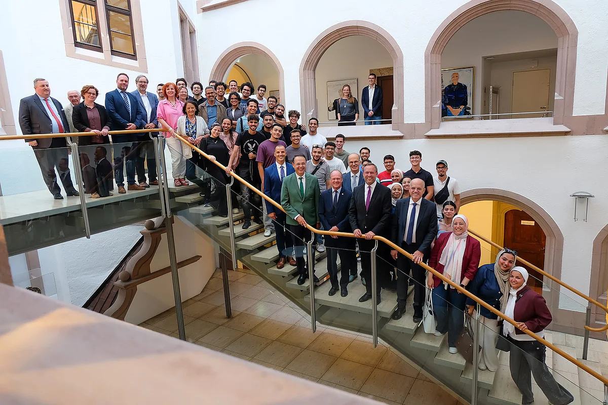 Großes Gruppenfoto: Mehrere Dutzend Menschen auf einer Treppe im Rathaus