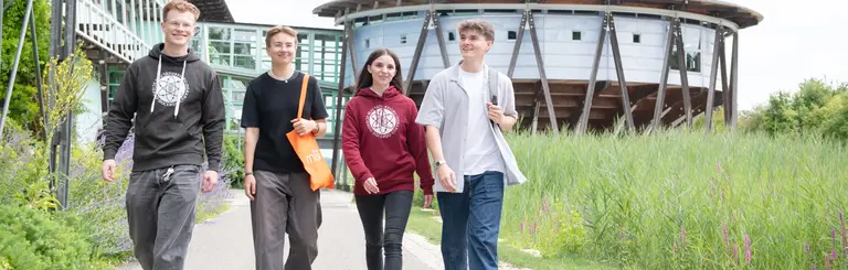Studierende laufen über den Campus an der Uni West