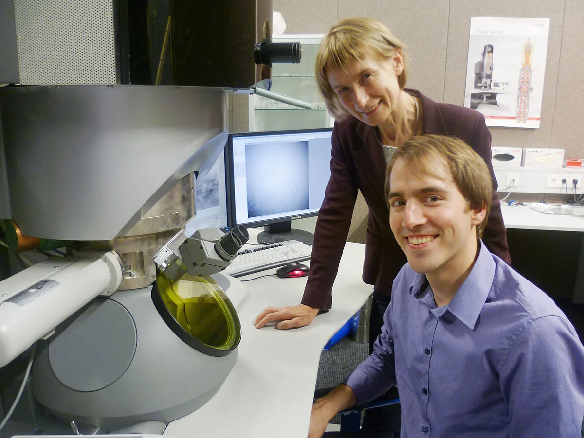 Die Ulmer Physiker Prof. Dr. Ute Kaiser und Simon Kurasch am höchst-auflösenden Elektronenmikroskop.
Die Abbildung zeigt die von W.H. Zachariasen 1932 postulierte Atomstruktur von Siliziumdioxid im Modell sowie im Hintergrund die Elektronenmikroskopisc