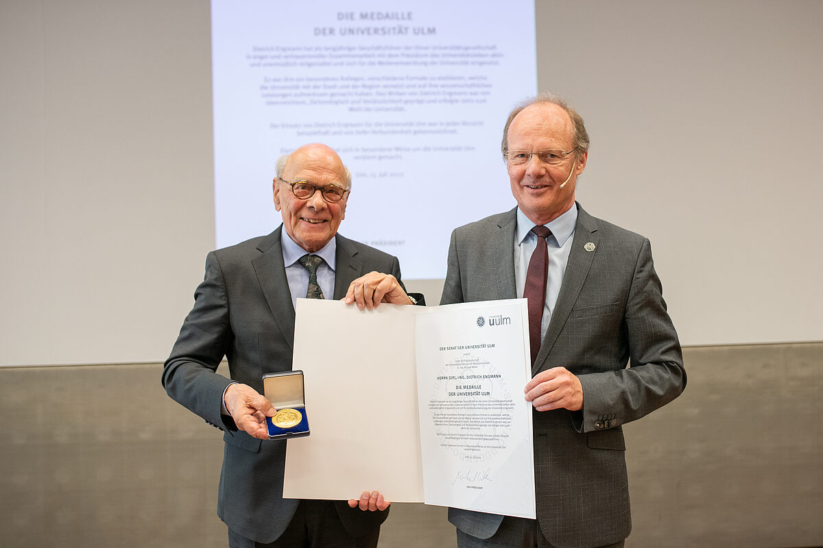 Der langjährige UUG-Geschäftsführer, Dietrich Engmann (links), erhält die Universitätsmedaille von Uni-Präsident Prof. Michael Weber 