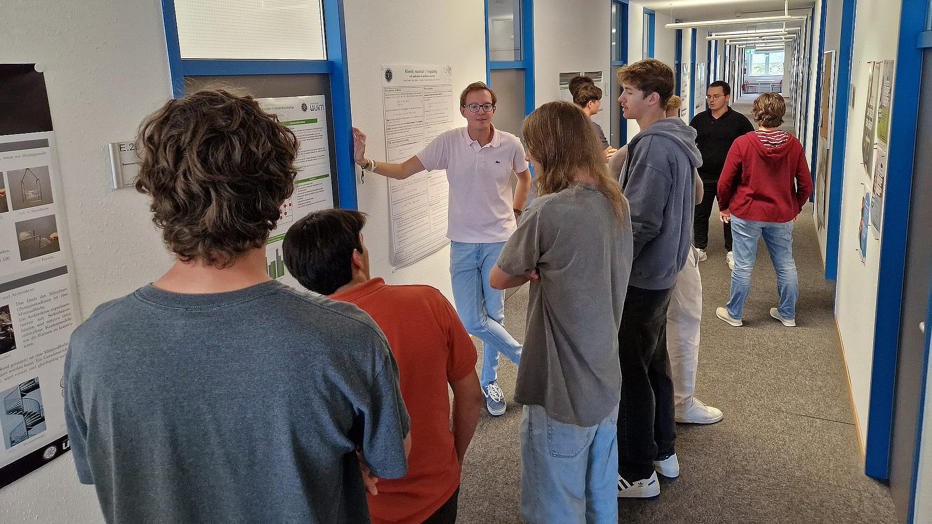 Poster session at the MaWi Summer Camp – prospective students discuss a doctoral candidate's work with him