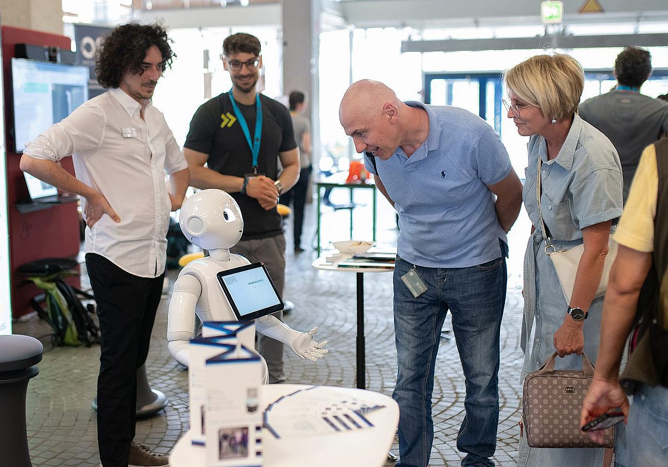 Stand of the Entrepreneurs Campus at the Long Evening of Science 2024. People interacting with a robot.
