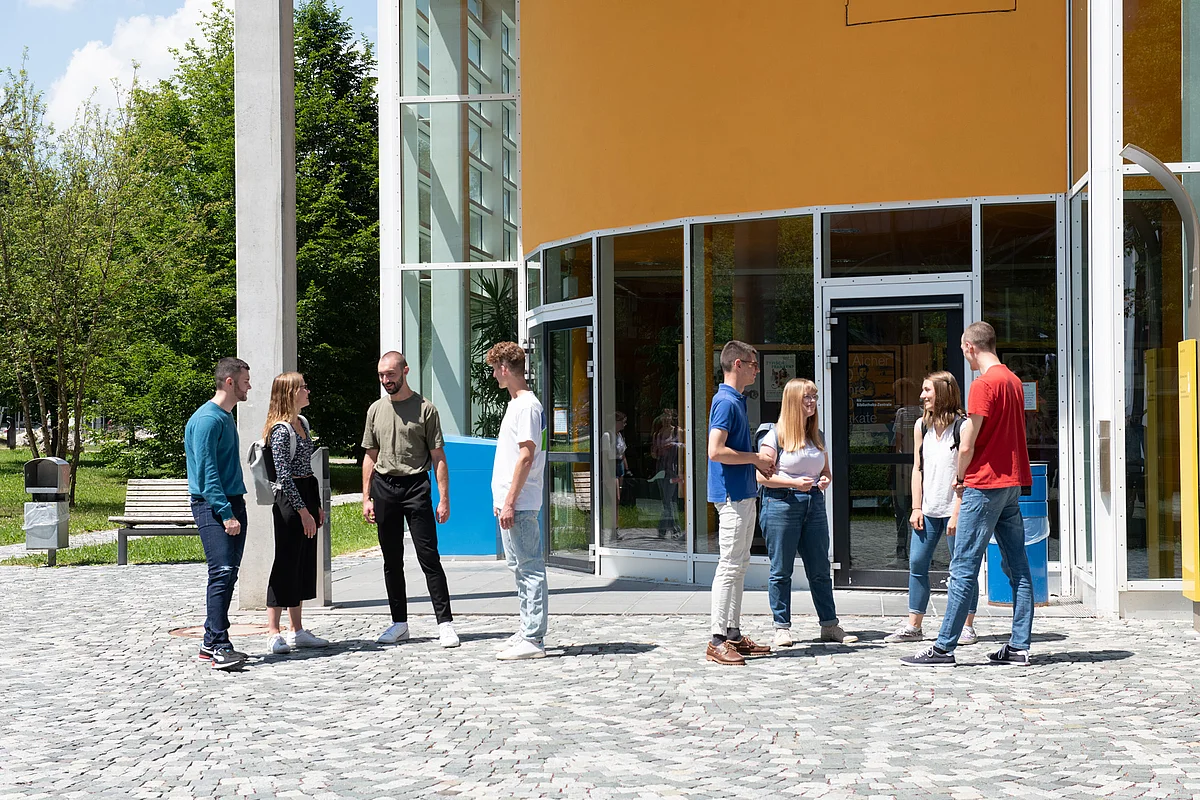 Students stand in front of the library of Ulm University