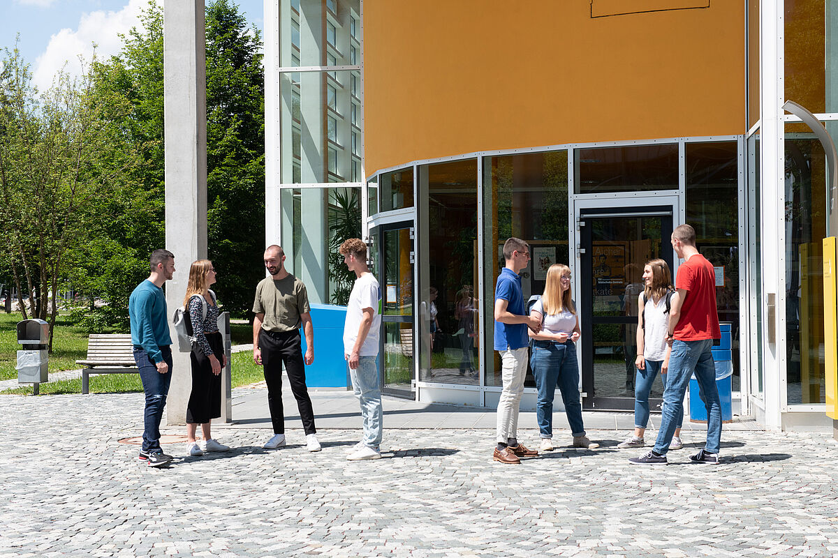 Studierende stehen vor der Bibliothek der Uni Ulm