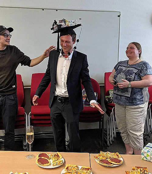 Michael Rietzler (mitte) mit dem Doktorhut