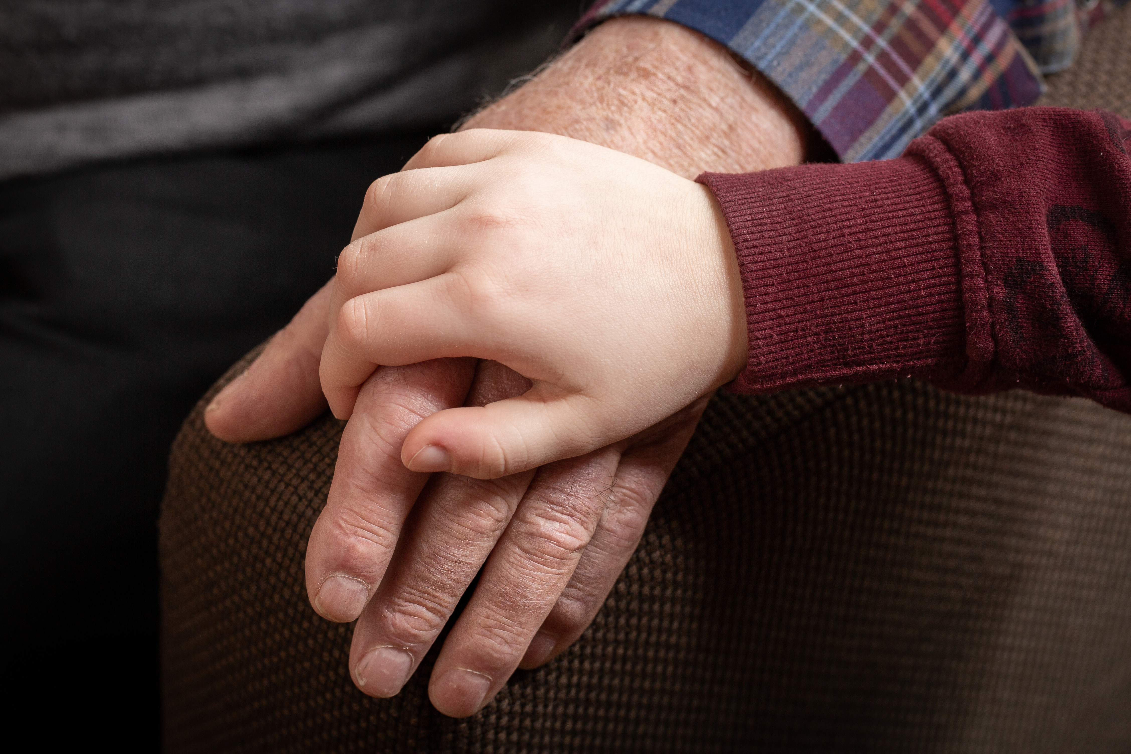 Junge Hand liegt auf alter Hand