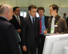 Dr. Thorsten Liebig (re.) erklärt Ulirich Dietz (GFT) und Minister Dr. Nils Schmid das Programm