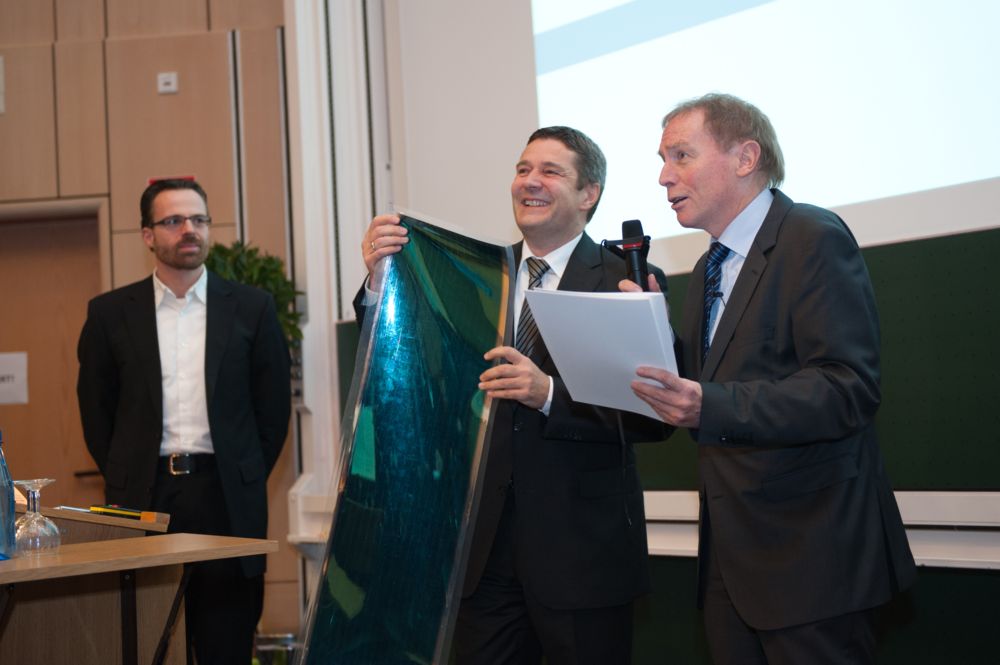 Prof. Dr. Bäuerle wird der Kooperationspreis für seine Zusammenarbeit mit der Firma Heliatek verliehen. Foto des Preisträgers Prof. Dr. Bäuerle und eines Vertreters der Firma Heliathek