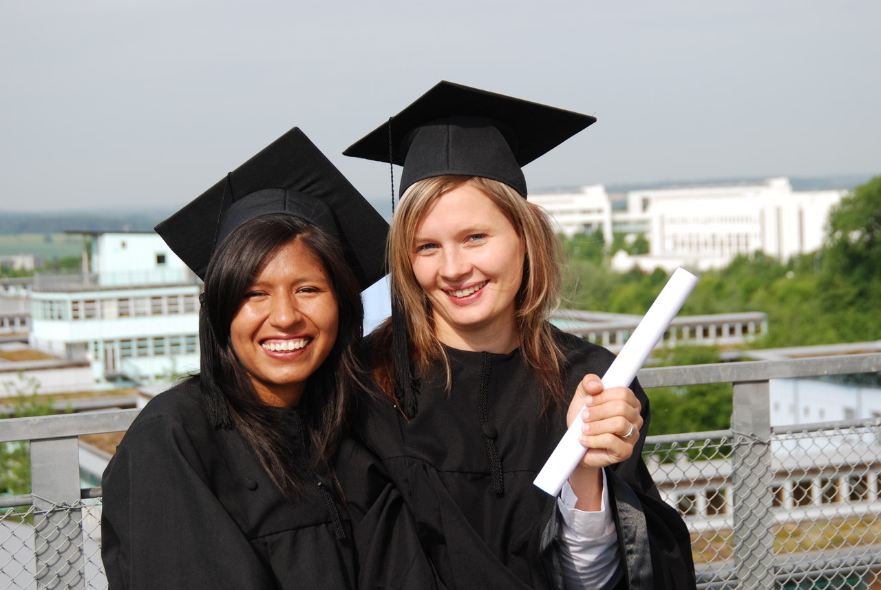 Recent graduates in cap and gown celebrate