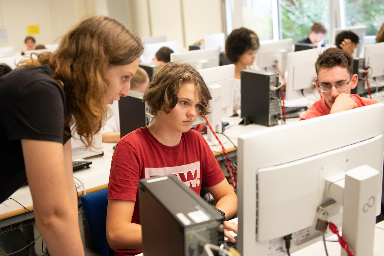 Eine Studierende hilft Studieninteressierte bei MatLab im Rahmen des MaWi Summer Camps