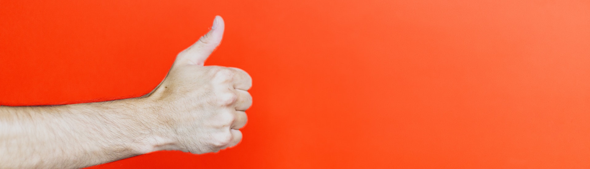 Thumbs up on a bright orange background