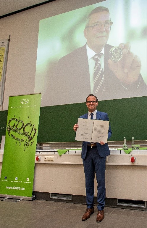 Prof. Schreiner präsentiert die Urkunde und Prof. Bäuerle die Emil-Fischer-Medaille während der Festveranstaltung. 