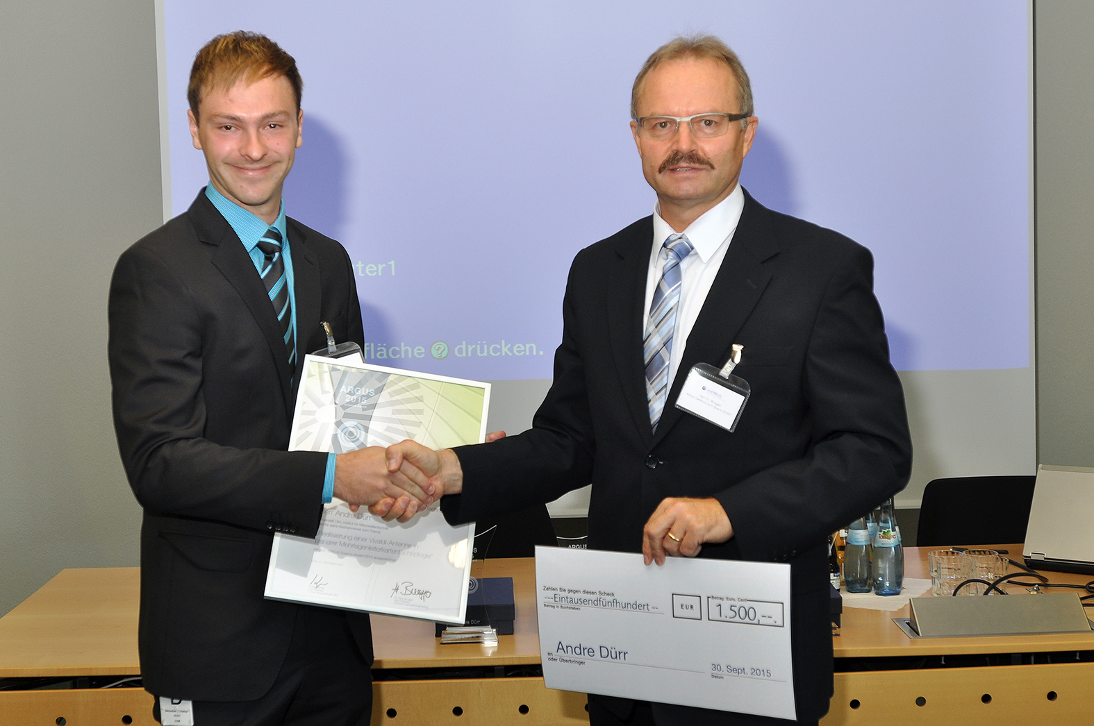 Dr. Hans  Brugger (Leiter Hardware-Entwicklung, Airbus Defence and Space) gratuliert Argus-Preisträger André Dürr